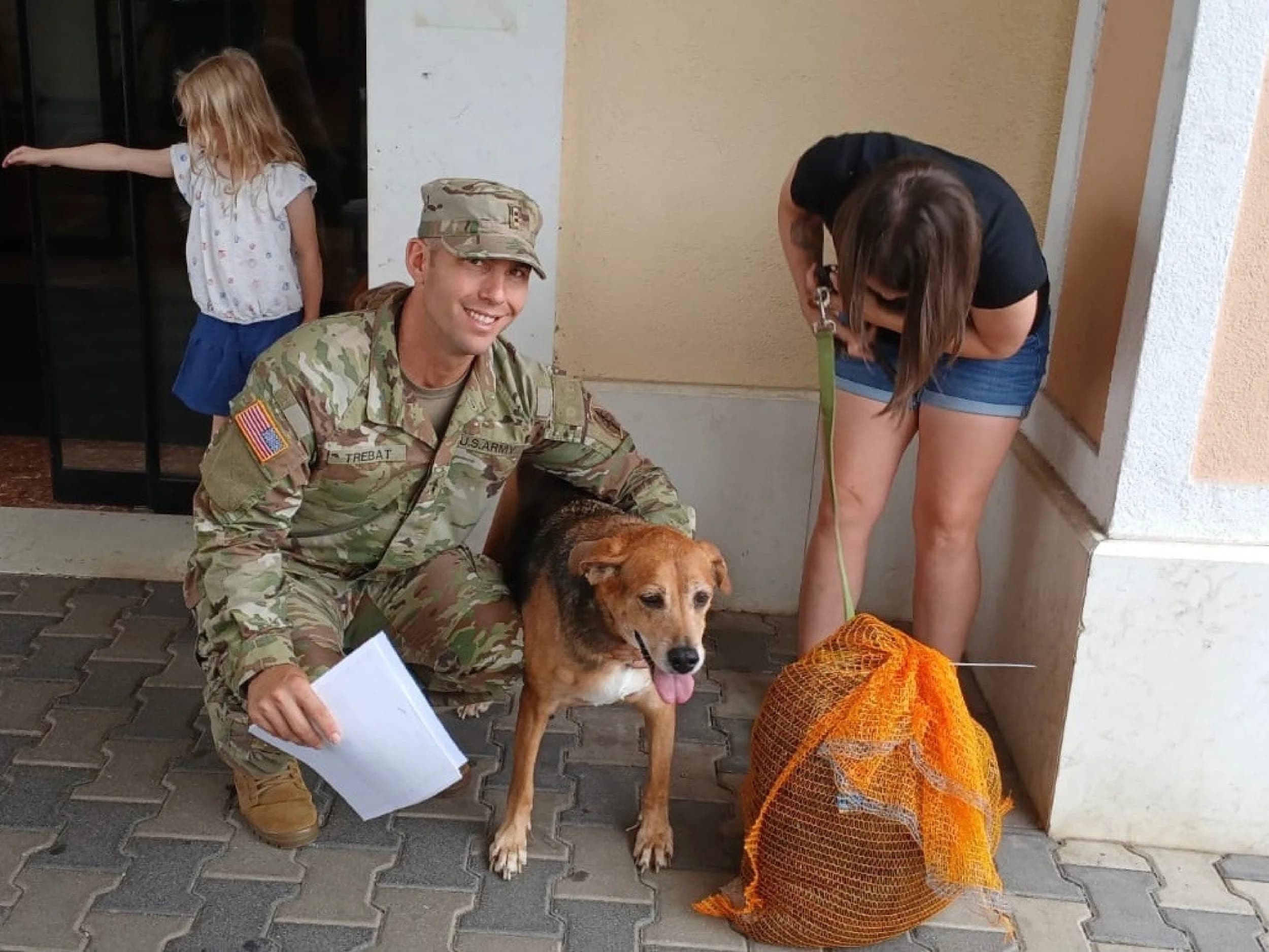 Service family with pet preparing a travel kennel for PCS